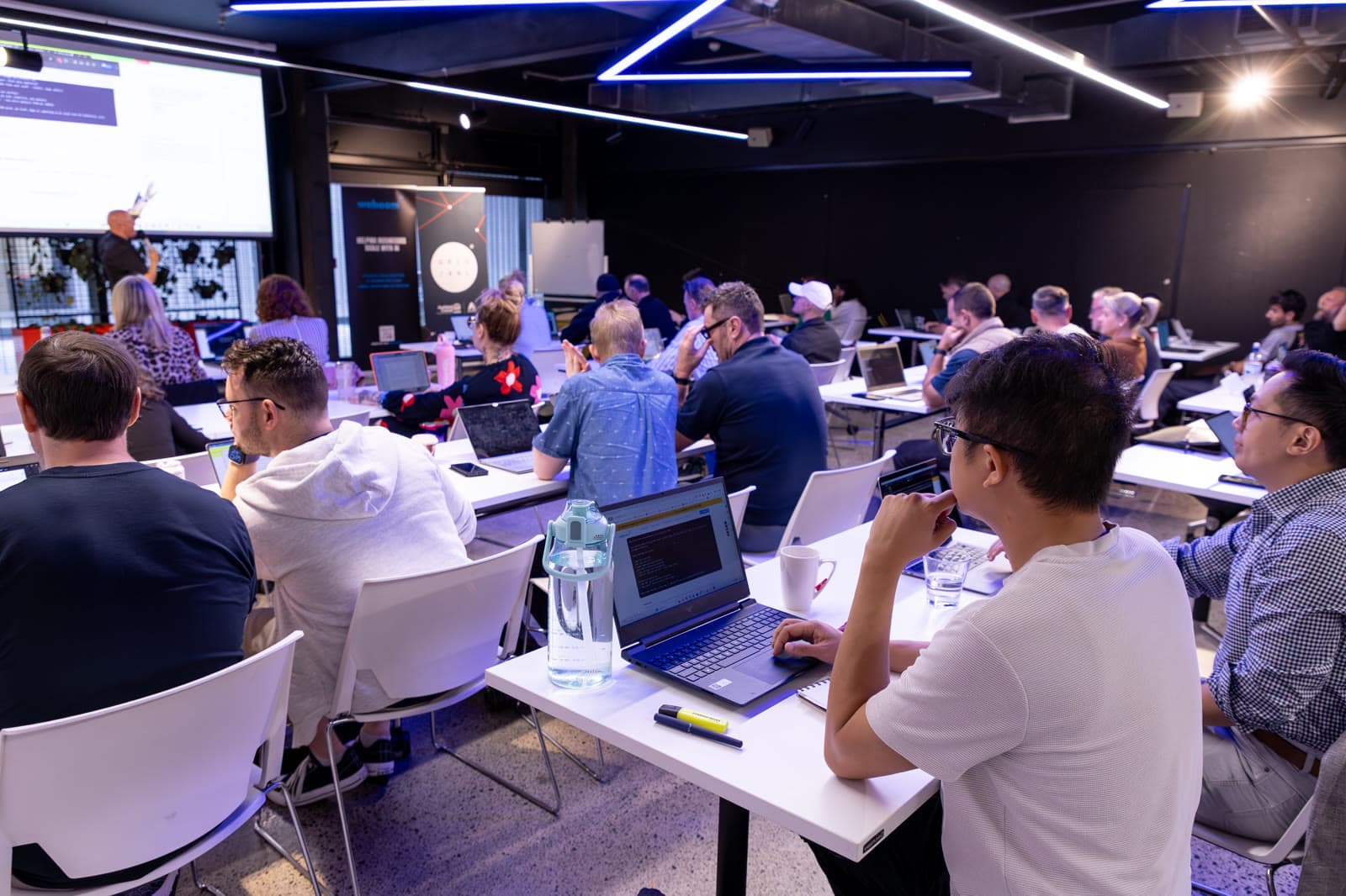 A full room of attendees on their laptops building AI agents at a hands-on Waboom AI workshop