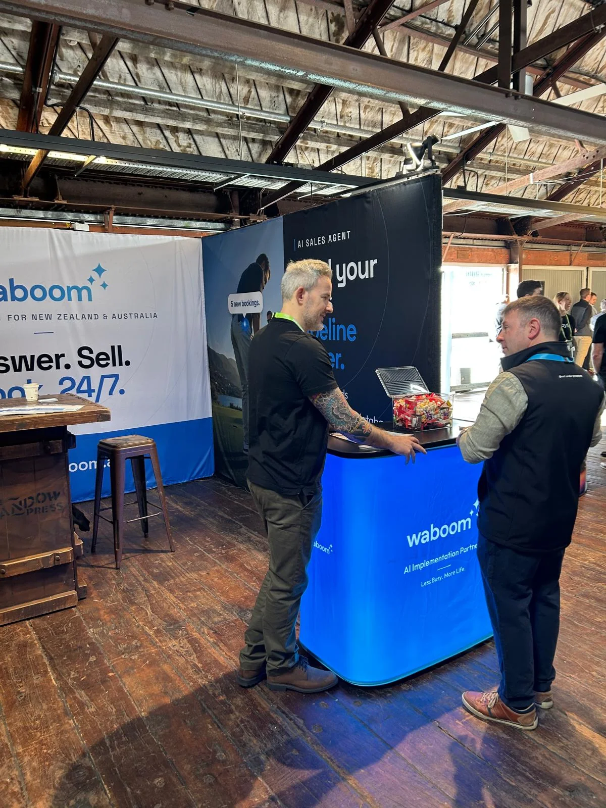 A visitor asking about AI voice agent adoption in New Zealand at the Waboom AI stand, NZ Tech Expo