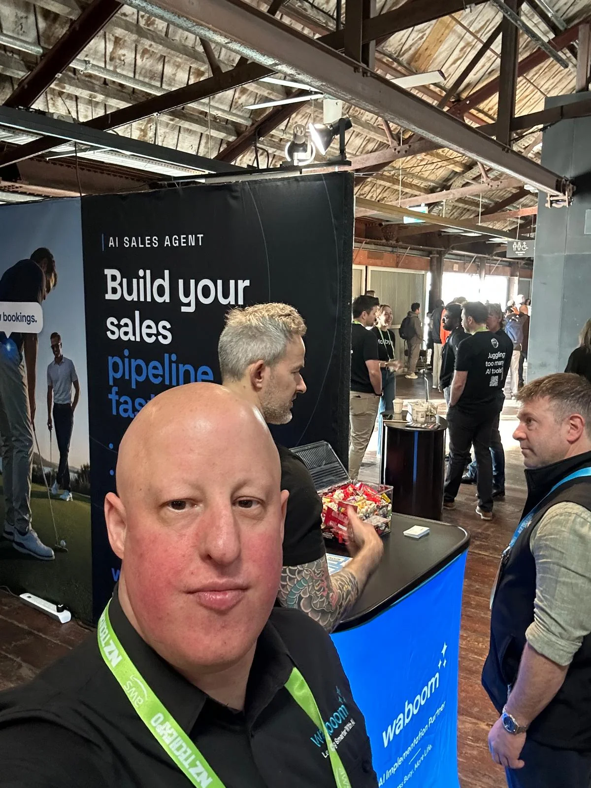 The Waboom AI team on the expo floor at NZ Tech Expo 2026 with attendees in the background